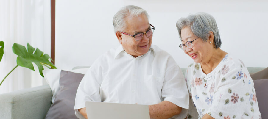 Senior Asian couple filling out a Guaranteed Income Supplement (GIS)